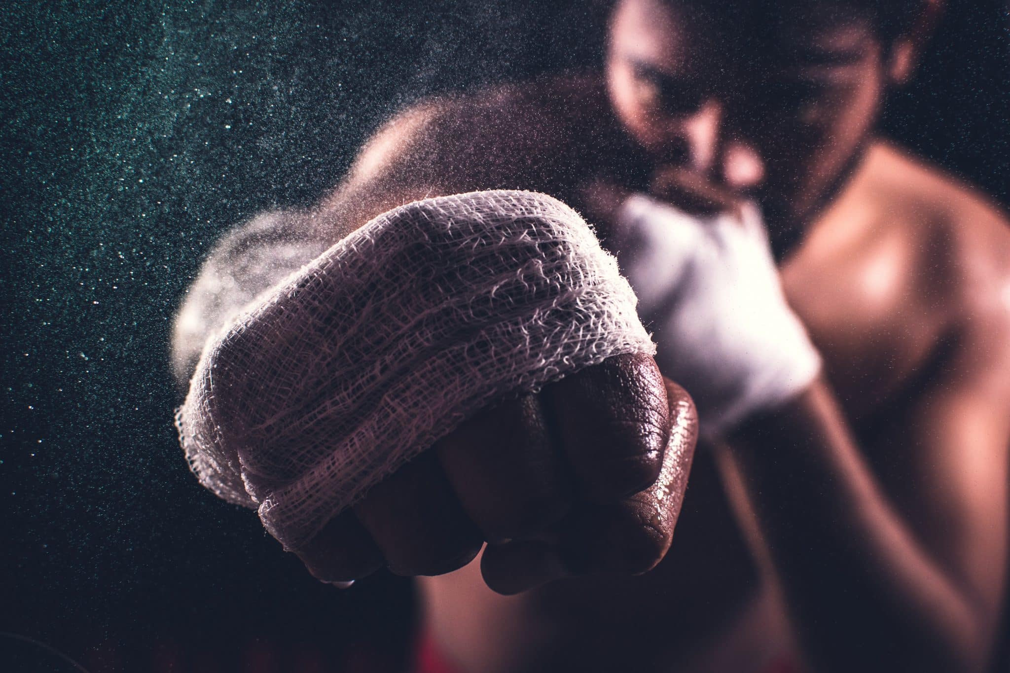 Boxer preparing for training, showcasing a wrapped fist, emphasizing athleticism and sports injury prevention relevant to chiropractic care for athletes.