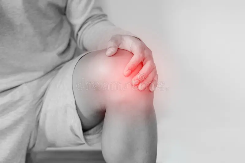 Man holding knee in pain, highlighting joint discomfort, relevant to joint pain treatment and chiropractic care.
